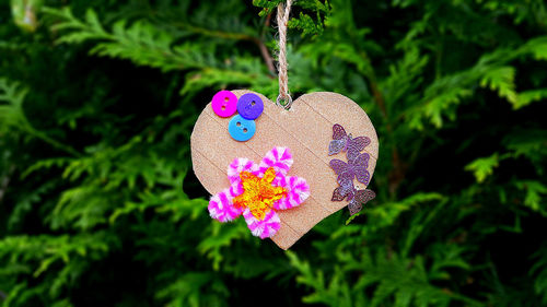 Close-up of heart shape hanging on pink tree
