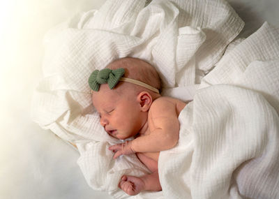 High angle view of cute baby sleeping on bed