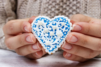 Close-up of woman holding heart shape cookie