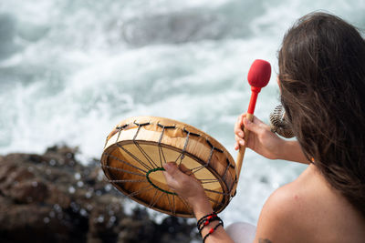 People are seen playing percussion instruments during a party for iemanja 