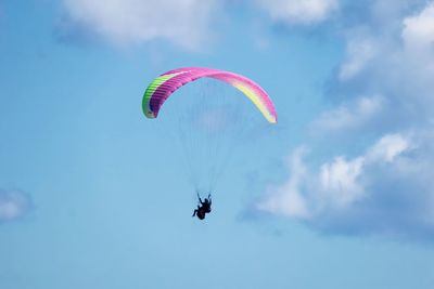 Low angle view of paragliding against sky
