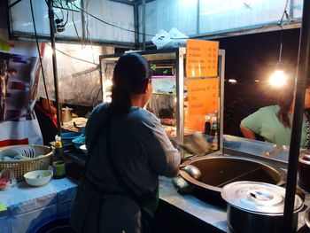 Rear view of woman working at dusk