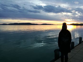 Rear view of man looking at sea against sky