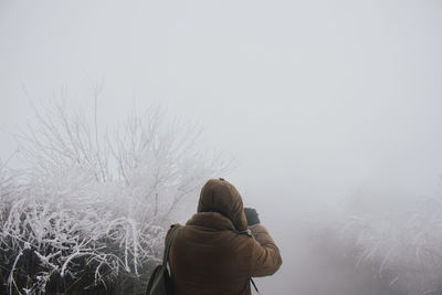 Rear view of woman on snow against sky