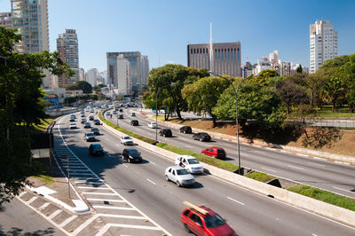 High angle view of traffic on road by buildings in city