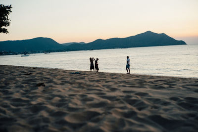 Friends standing on shore at beach