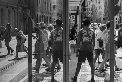 Reflection of people at city street on mirror