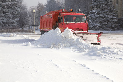 Snow covered land by road during winter