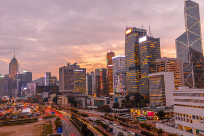 Modern buildings in city against sky during sunset