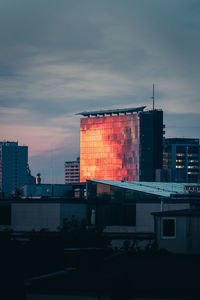 Buildings in city against sky at sunset