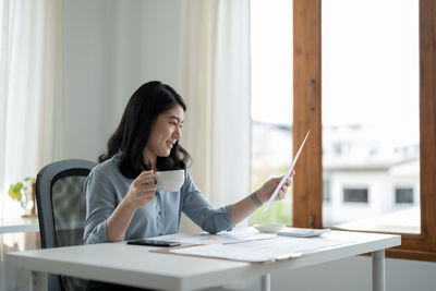 Young woman using mobile phone in office