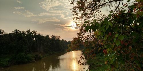 Scenic view of river against sky at sunset