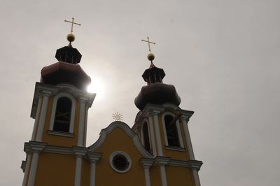 Low angle view of cross on building against sky