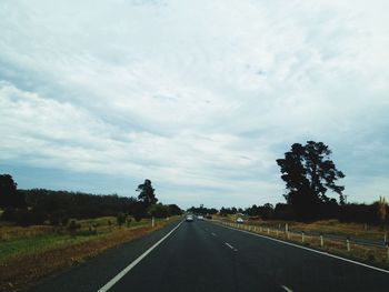 Empty road against cloudy sky