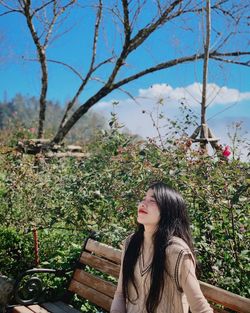 Woman with plants against trees