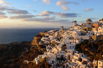 High angle view of townscape by sea against sky