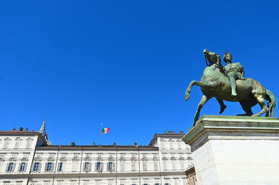 Low angle view of statue against blue sky