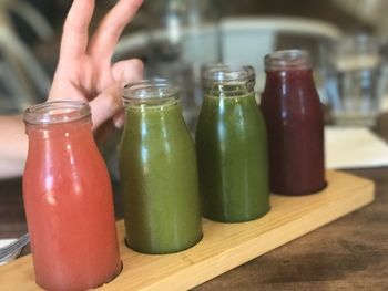 Close-up of hand holding drink on table