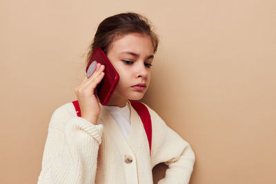 Young woman standing against pink background