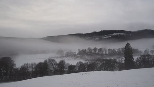 Scenic view of landscape against sky during winter