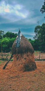 Traditional windmill on field against sky