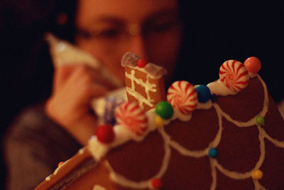 Close-up of woman icing on cake at home