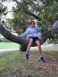 Portrait of young woman exercising on field