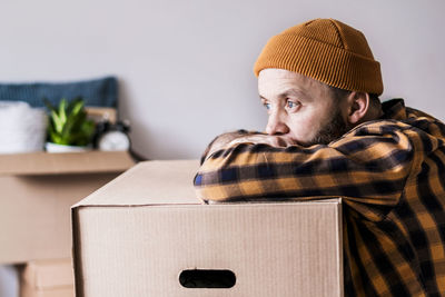 Mature man unpacking things from boxes while moving in new apartment.