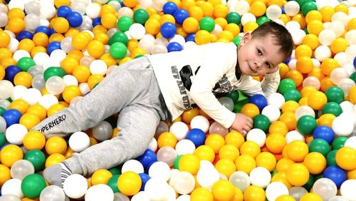 Portrait of boy relaxing on balls in pool