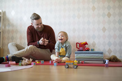 Portrait of siblings playing with toy blocks at home