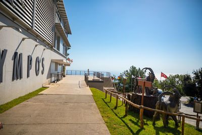 Footpath amidst buildings against clear sky