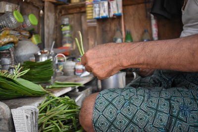 Midsection of man working with vegetables