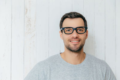 Portrait of handsome young man against wall