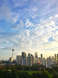 Modern buildings in city against cloudy sky