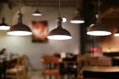 Illuminated pendant lights hanging in restaurant