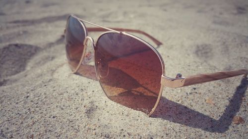 Close-up of sunglasses on sand