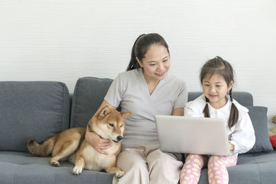 Friends sitting on sofa at home