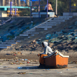 Rear view of man working on garbage