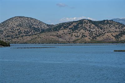 Scenic view of sea and mountains against blue sky