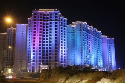 Illuminated buildings against sky at night