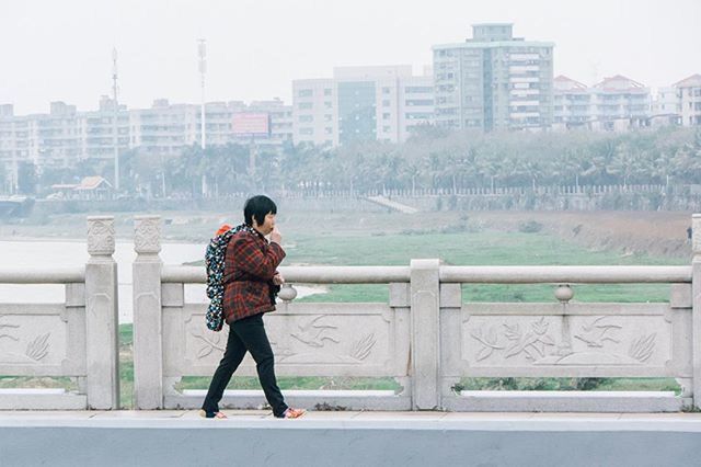 building exterior, full length, rear view, architecture, built structure, lifestyles, standing, casual clothing, men, walking, city, leisure activity, clear sky, day, building, person, city life, side view