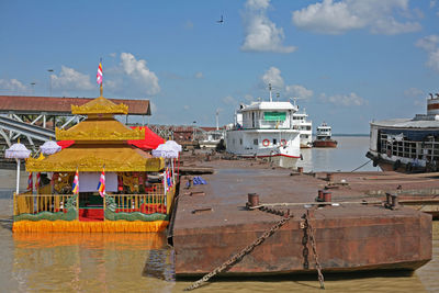 Fishing boats moored on building against sky