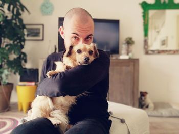 Portrait of dog sitting on sofa at home