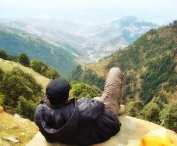 Rear view of man on mountain against sky