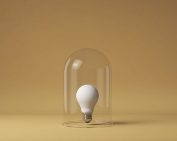 Close-up of light bulb on beige background