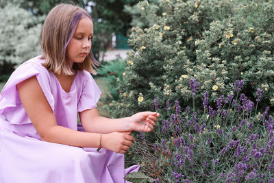 Portrait of young woman standing amidst plants