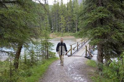 Full length of man walking by footbridge at banff national park