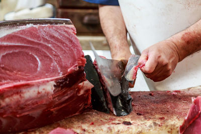Close-up of man cutting tuna