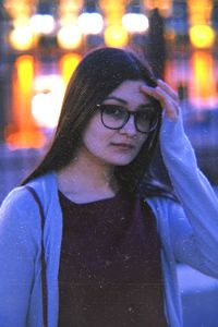 Portrait of young woman standing in city during winter