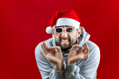 Portrait of man wearing hat against red background